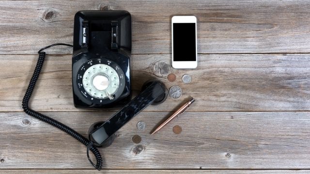 landline-and-mobile-phones-next-to-money